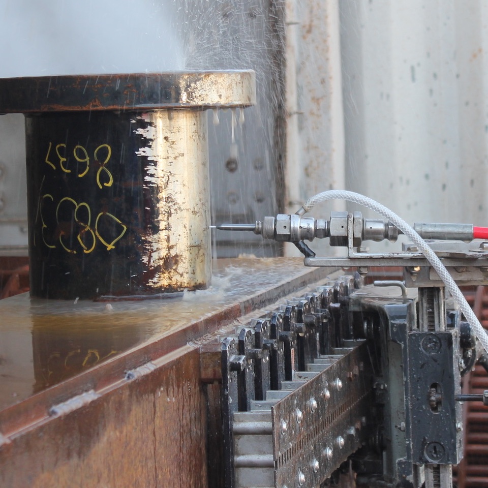 Close-up of cold cutting nozzle and track system during operation